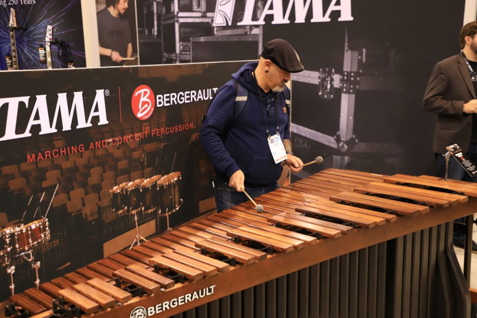 an attendee plays a marimba at the tama booth at the namm show