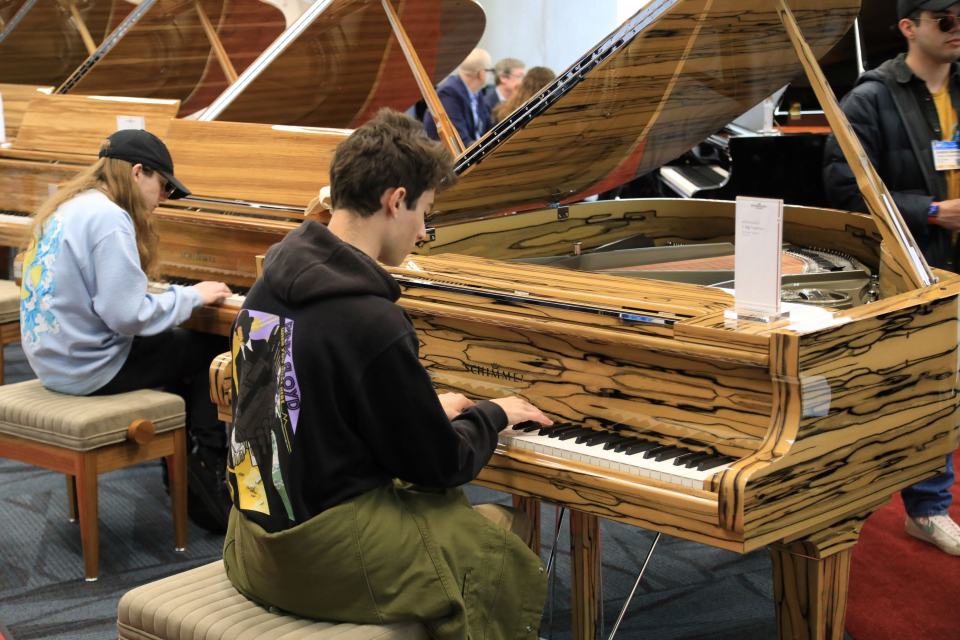 attendees demo pianos at the namm show