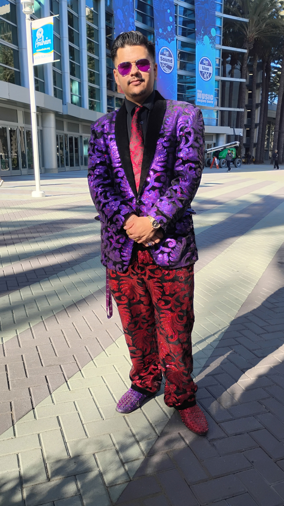 man in a purple and red glitter suit at the namm show