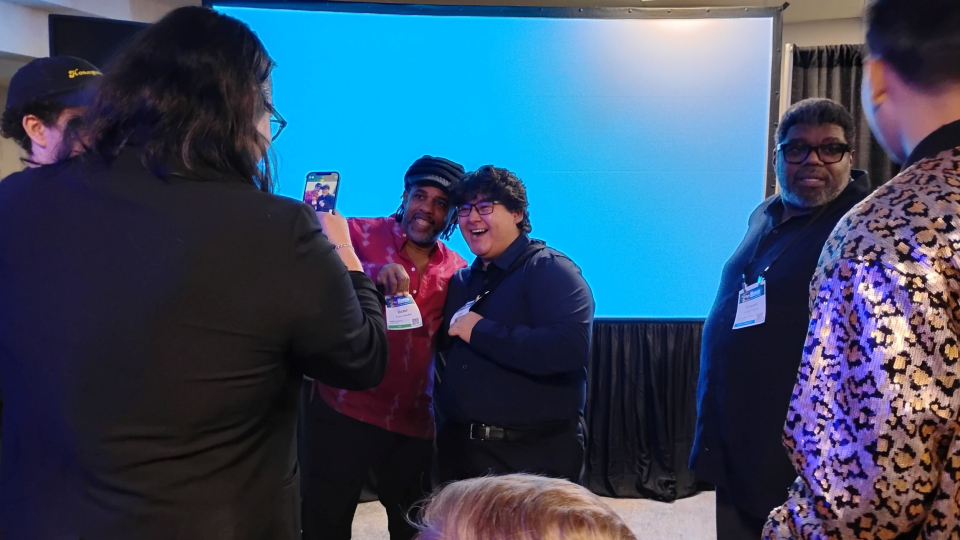 victor wooten takes a picture with a student fan at the namm show