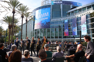 a brass band plays in front of the anaheim convention center for the namm show